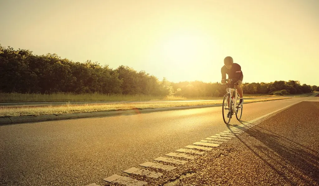 athlete on biking on raod alone 