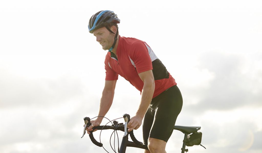 Cyclist standing out of saddle wearing cycling clothes