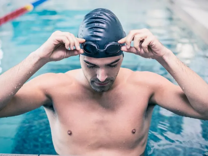 Handsome-man-wearing-swim-cap-and-goggles-at-the-pool