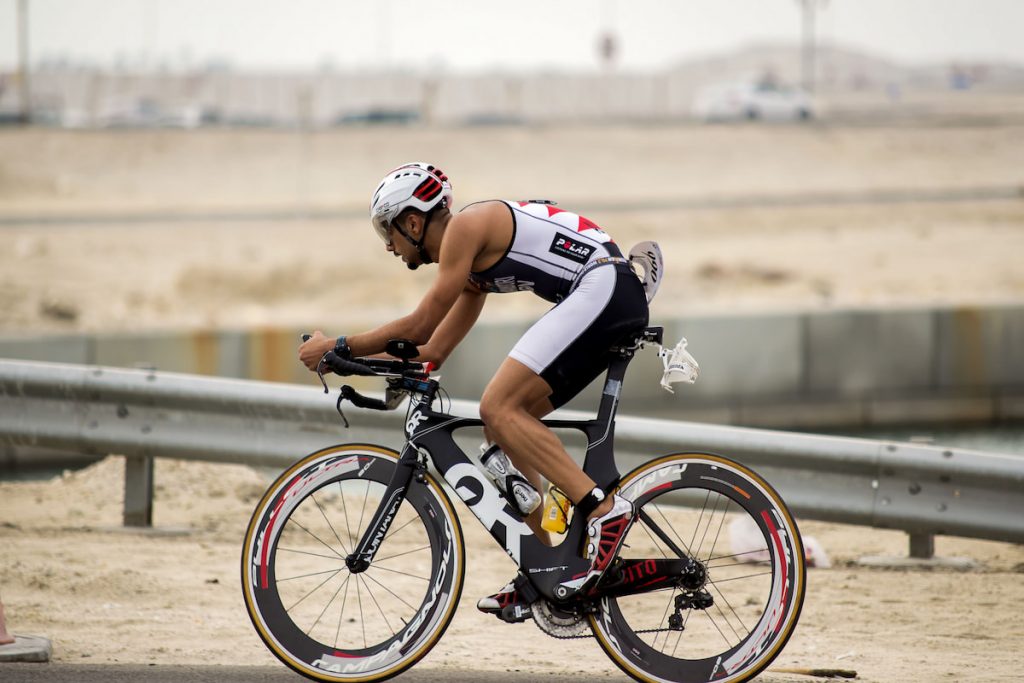 Triathlete riding his triathlon bike with aero bars