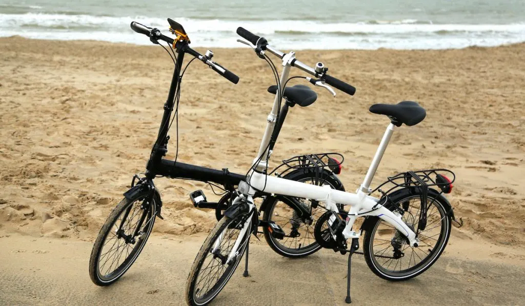 Two folding bicycles on beach