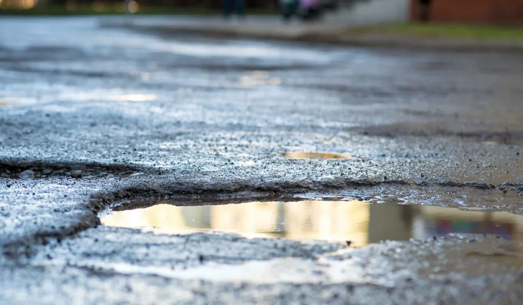 closeup of big potholes on rough road