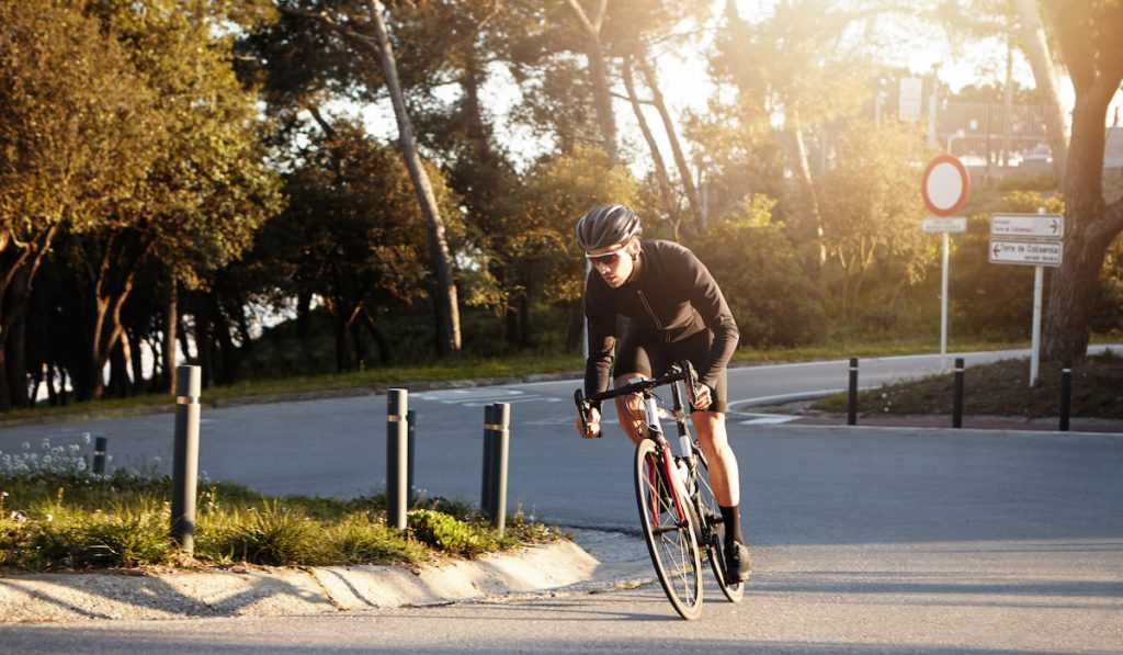 cyclist wearing sunglasses and helmet speeding on his racing bike