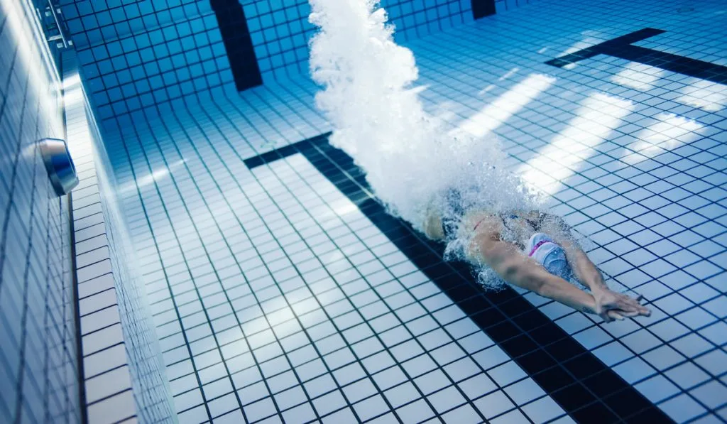 female swimmer gliding in swimming pool