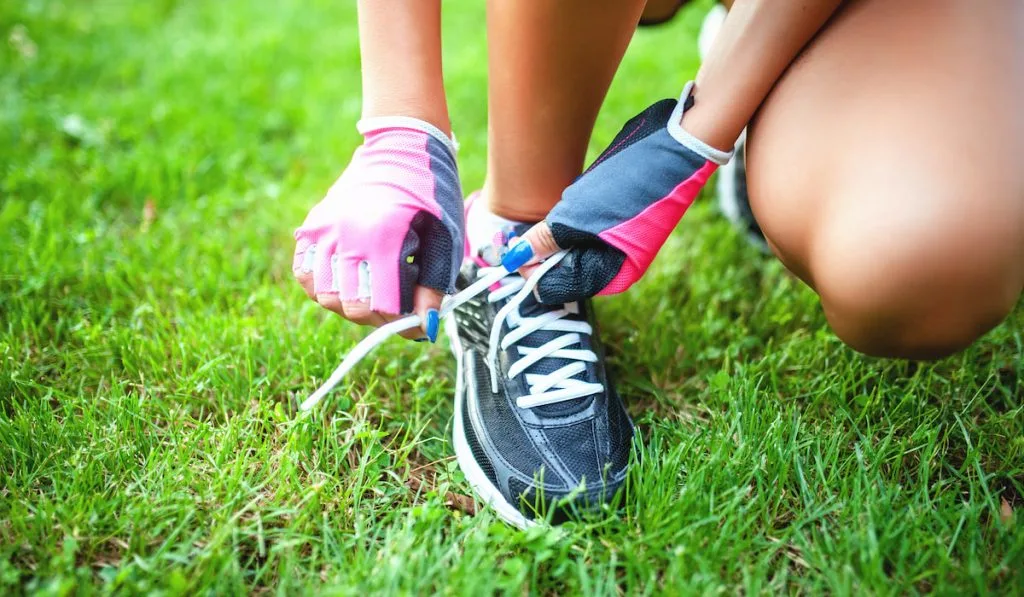 female triathlete preparing her shoes for running 