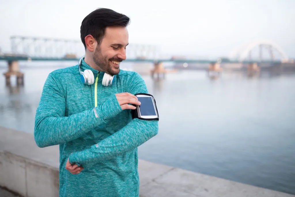 healthy sportsman exercising checking fitness app