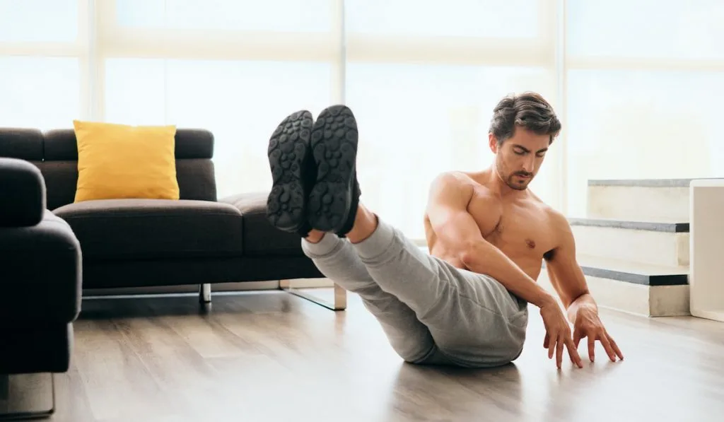 man At Home Doing Russian Twist Exercise